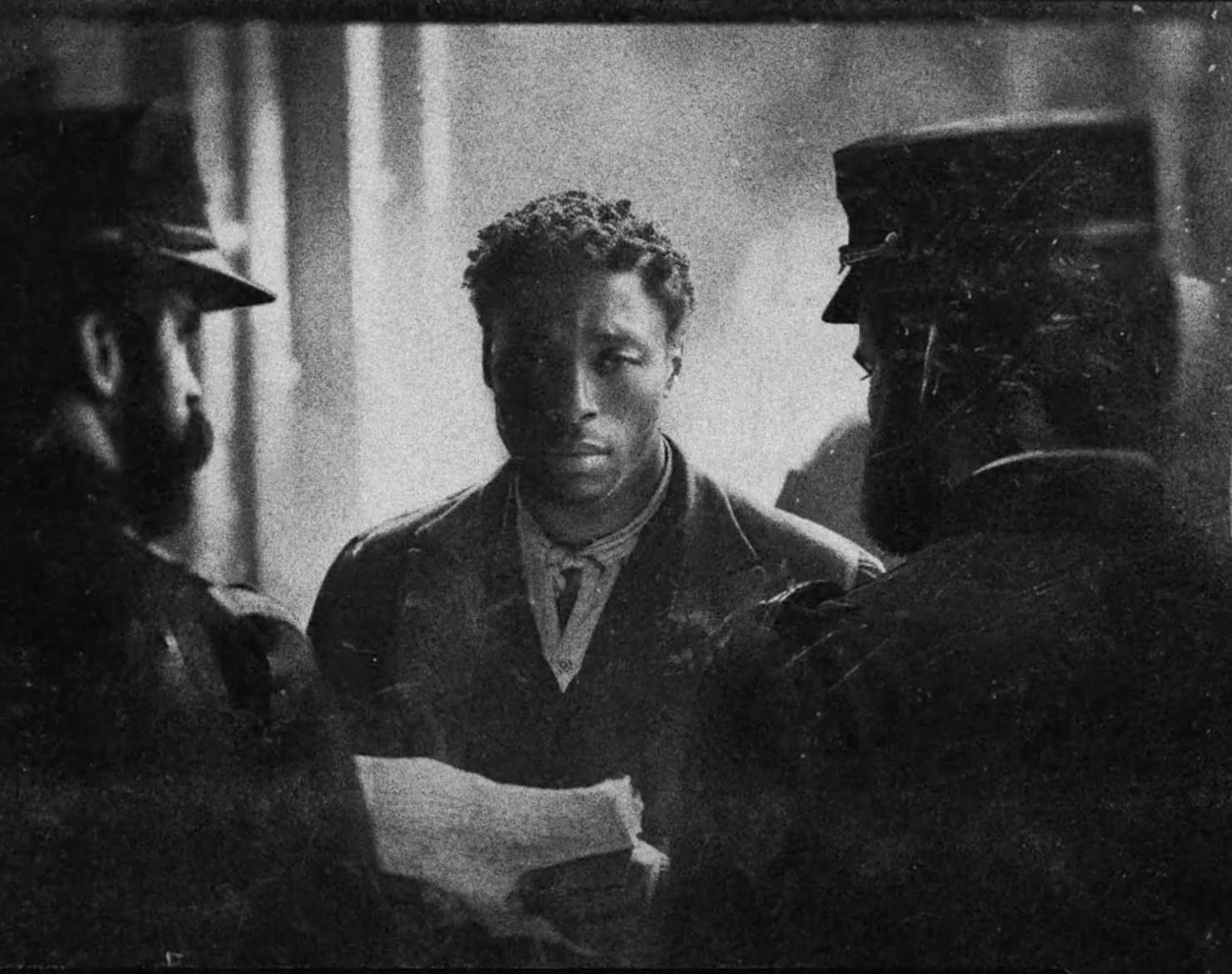 Film still of Black man securing bond. 